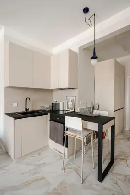 a kitchen with a black table and white cabinets at Stylish 1BD Apartment in the Heart of the City by Flat Mаnager in Sofia