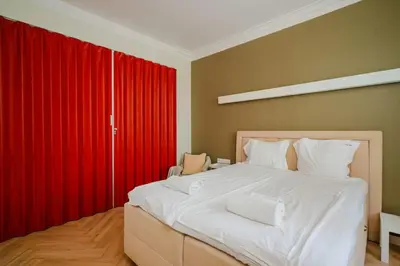 a bedroom with a large white bed with red curtains at Stylish 1BD Apartment in the Heart of the City by Flat Mаnager in Sofia