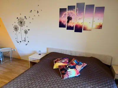 a room with a bed with paintings on the wall at Aspen Suites Студио Слънчев ден in Razlog