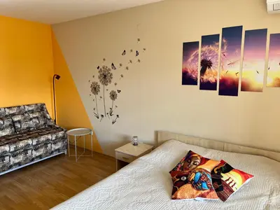 a bedroom with a bed and some pictures on the wall at Aspen Suites Студио Слънчев ден in Razlog