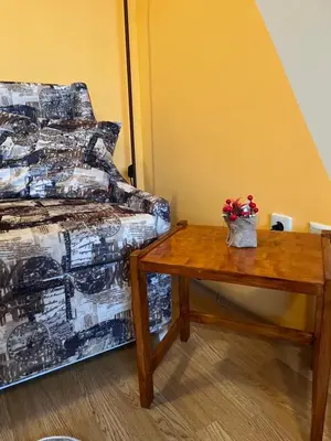 a room with a bed and a table with flowers on it at Aspen Suites Студио Слънчев ден in Razlog
