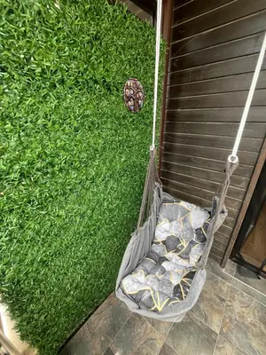 a hammock on the side of a house with grass at Aspen Suites Студио Слънчев ден in Razlog