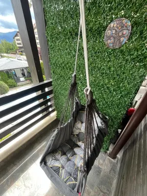 a hammock hanging on a porch next to a window at Aspen Suites Студио Слънчев ден in Razlog