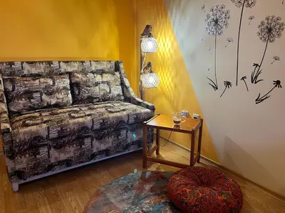a living room with a bed and a table with a stool at Aspen Suites Студио Слънчев ден in Razlog