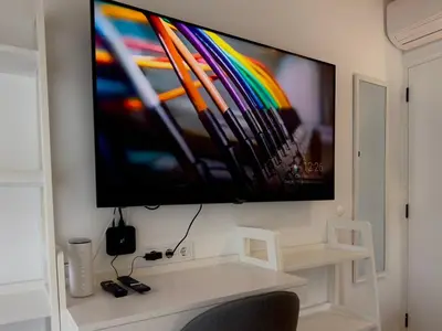 a flat screen tv on a wall above a desk at Spa Villa Mezinska Jacuzzi Sauna in Shiroka Lŭka