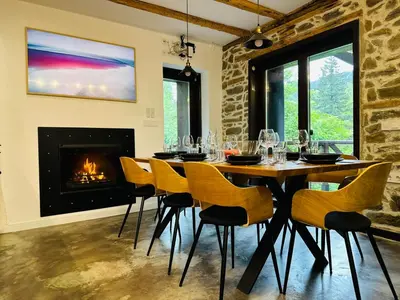 a dining room with a table and chairs and a fireplace at Spa Villa Mezinska Jacuzzi Sauna in Shiroka Lŭka