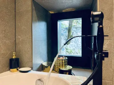 a bathroom with a sink with a shower head at Spa Villa Mezinska Jacuzzi Sauna in Shiroka Lŭka