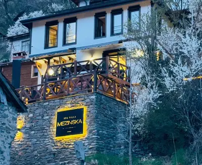 a house with a balcony on top of a stone wall at Spa Villa Mezinska Jacuzzi Sauna in Shiroka Lŭka