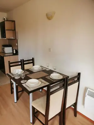 a dining room table and chairs with plates and wine glasses at ICEBERG Ski Apartment No19 in Pamporovo