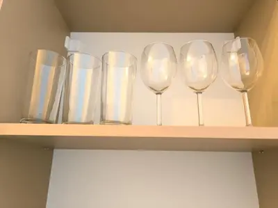 a row of wine glasses sitting on a shelf at My Campus Studios, free parking, self-check in in Sofia