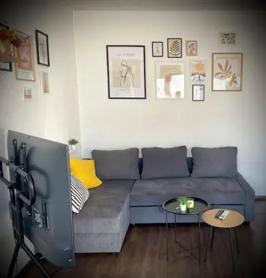 a living room with a blue couch and two tables at Cozy APT Free Parking Wi-Fi Netflix in Sofia