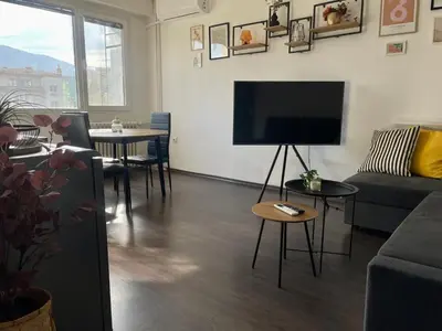 a living room with a couch and a flat screen tv at Cozy APT Free Parking Wi-Fi Netflix in Sofia