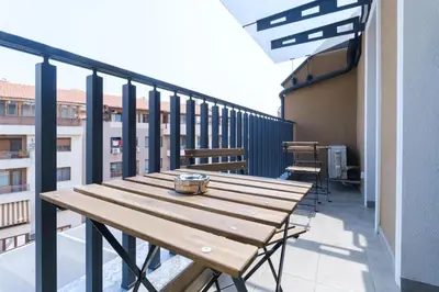 a wooden table on the balcony of a building at LDV 13 Apartments Free private parking in Plovdiv