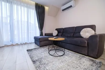a living room with a black couch and a table at LDV 13 Apartments Free private parking in Plovdiv