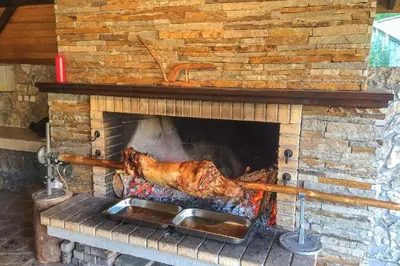 a piece of meat cooking in a brick fireplace at Stream Spa Suite in Pamporovo