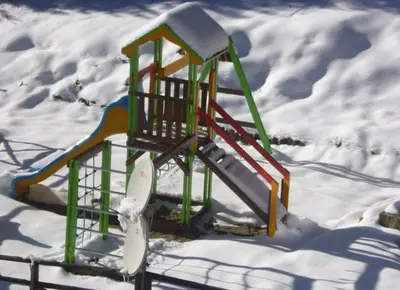 a playground in the snow with a slide at Stream Spa Suite in Pamporovo