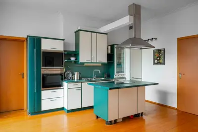 a kitchen with green cabinets and a blue counter top at Charming 2BD Apartment in the Heart of the City by Flat Mаnager in Sofia