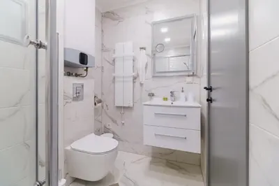 a white bathroom with a toilet and a sink at LDV 13 Residence Free private parking in Plovdiv