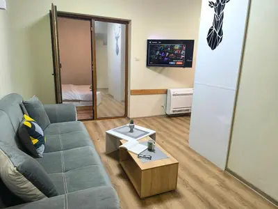 a living room with a blue couch and a table at Snow White - Luxury Stay with free Bottle of Wine in Bansko