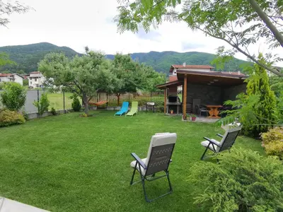 a yard with two lawn chairs and a house at Guest House Vessyta in Sapareva Banya
