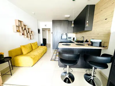a kitchen and living room with a yellow couch at Best View Studio in Sofia
