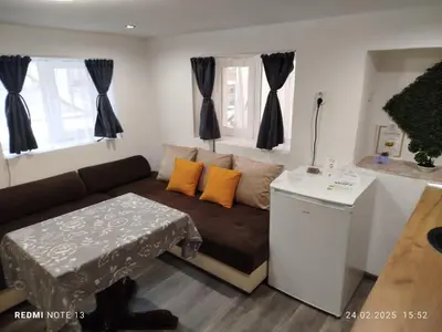 a living room with a couch and a table at Къща за гости Съкровище in Panagyurishte