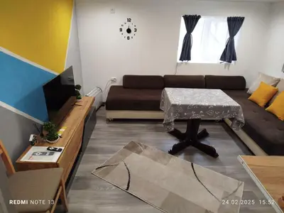 a living room with a couch and a table at Къща за гости Съкровище in Panagyurishte