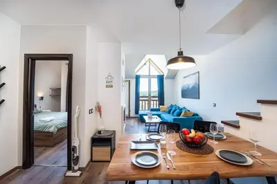 a living room with a table with a bowl of fruit on it at Alpin Penthouse 2 Bedroom with Fireplace and Mountain View in Bansko