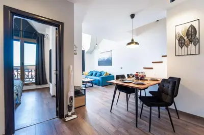 a dining room and living room with a table and chairs at Alpin Penthouse 2 Bedroom with Fireplace and Mountain View in Bansko