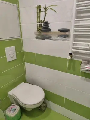 a green and white bathroom with a toilet and a mirror at Only You Boutique Apartment in Sofia