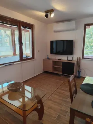 a living room with a flat screen tv and a table at Only You Boutique Apartment in Sofia