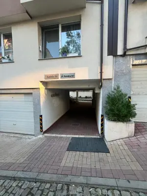 a building with a parking lot with a garage at Уютен тристаен апаратамент,намиращ се на тиха и спокойна улица in Sofia