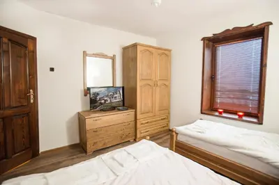 a bedroom with two beds and a dresser and a window at Guest House Panorama in Gela