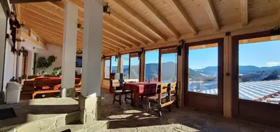 a dining room with a table and views of mountains at Guest House Panorama in Gela