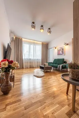 a living room with wooden floors and a green couch at Vespa Home Boutique Apartment in Sofia
