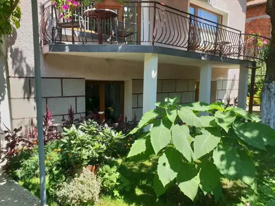 a house with a balcony and plants in front of it at Kyurkchievi Guest House in Sapareva Banya