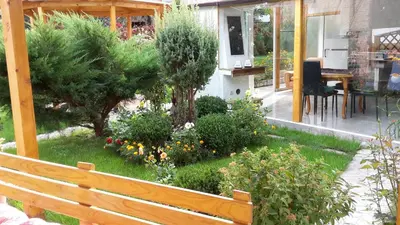 a wooden bench in front of a garden at Kyurkchievi Guest House in Sapareva Banya