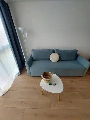a living room with a blue couch and a table at Sky Hills 2 Apartment in Sandanski