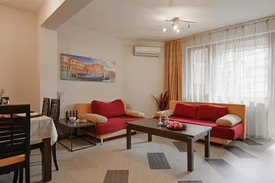 a living room with two red couches and a table at SouthPark Luxe - Free Underground Parking - Metro in Sofia