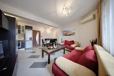 a living room with a red couch and a table at SouthPark Luxe - Free Underground Parking - Metro in Sofia