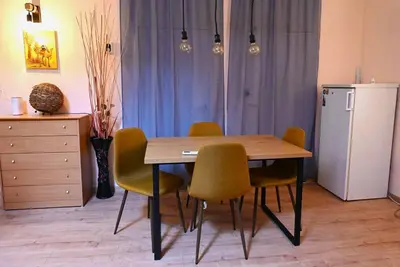 a dining room table with chairs and a refrigerator at National Theatre Loft in Sofia