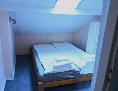 a room with a bed with white sheets and towels at National Theatre Loft in Sofia