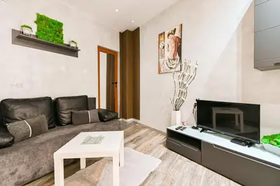 a living room with a couch and a tv at Velar 1BDR Apartment in Sofia