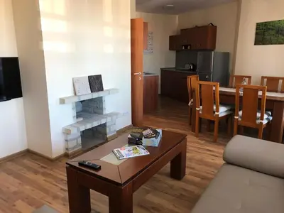 a living room with a couch and a table and a kitchen at Spacious 2 Bed Apartment Close To Gondola in Bansko