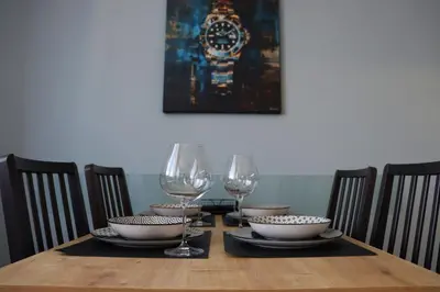 a wooden table with two wine glasses and bowls at New Sofia Sunset 1BDRM, Free Parking and Terrace in Sofia