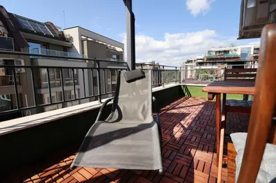 a metal bench sitting on a balcony with a table at New Sofia Sunset 1BDRM, Free Parking and Terrace in Sofia