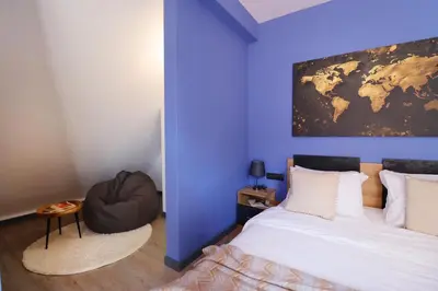 a bedroom with a large bed and a blue wall at New Sofia Sunset 1BDRM, Free Parking and Terrace in Sofia