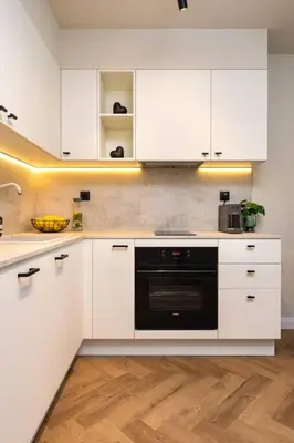 a kitchen with white cabinets and a black dishwasher at Olive Green Designer Apartment in Plovdiv