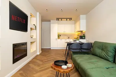 a living room with a green couch and a table at Olive Green Designer Apartment in Plovdiv