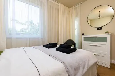a bedroom with a large white bed with a mirror at Olive Green Designer Apartment in Plovdiv